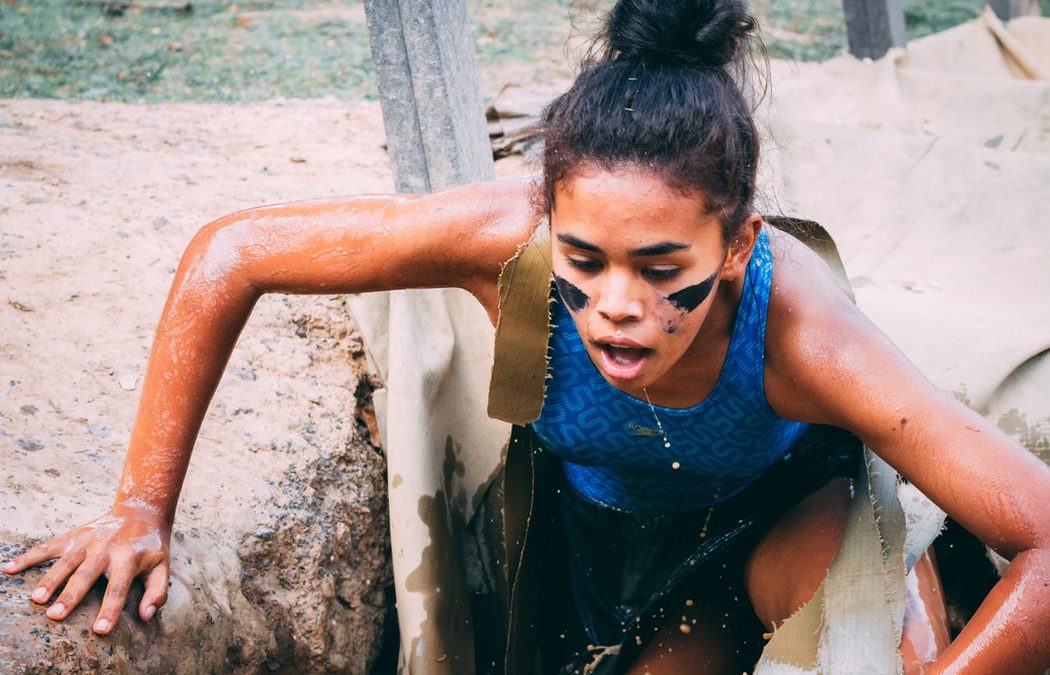 Woman fighting through a low muddy point to ultimate success